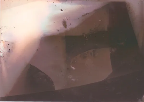 Faint pale geometric shapes in a soft purple-brown haze