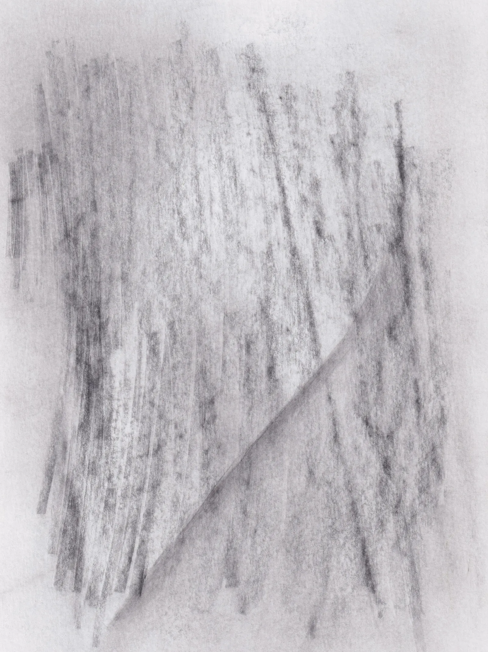 Soft vertical graphite strokes on white paper, cut by a single diagonal crease of tone
